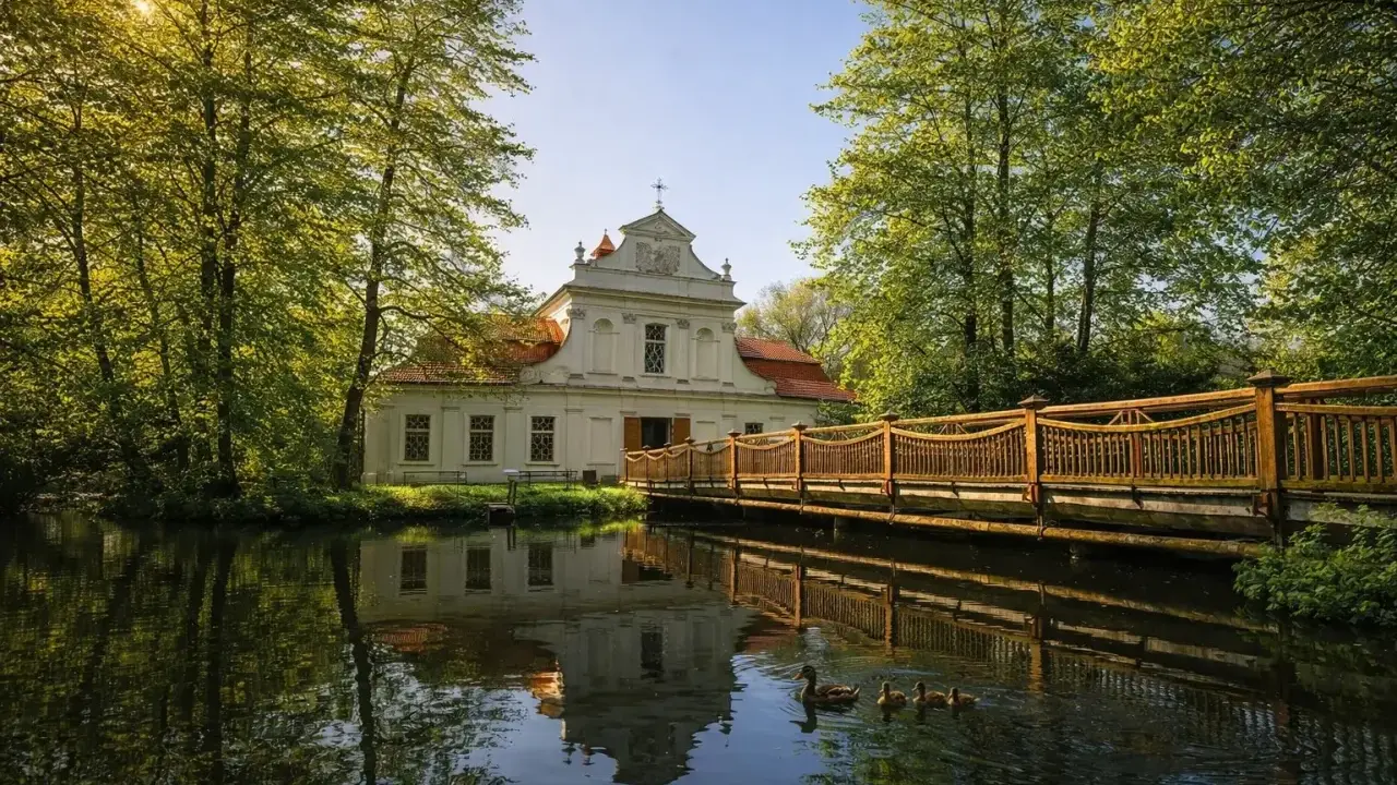 Urokliwy dworek otoczony zielenią, z drewnianym mostkiem i kaczą rodziną na stawie. Idealne miejsce na spędzenie **roztocze w jeden dzień**.