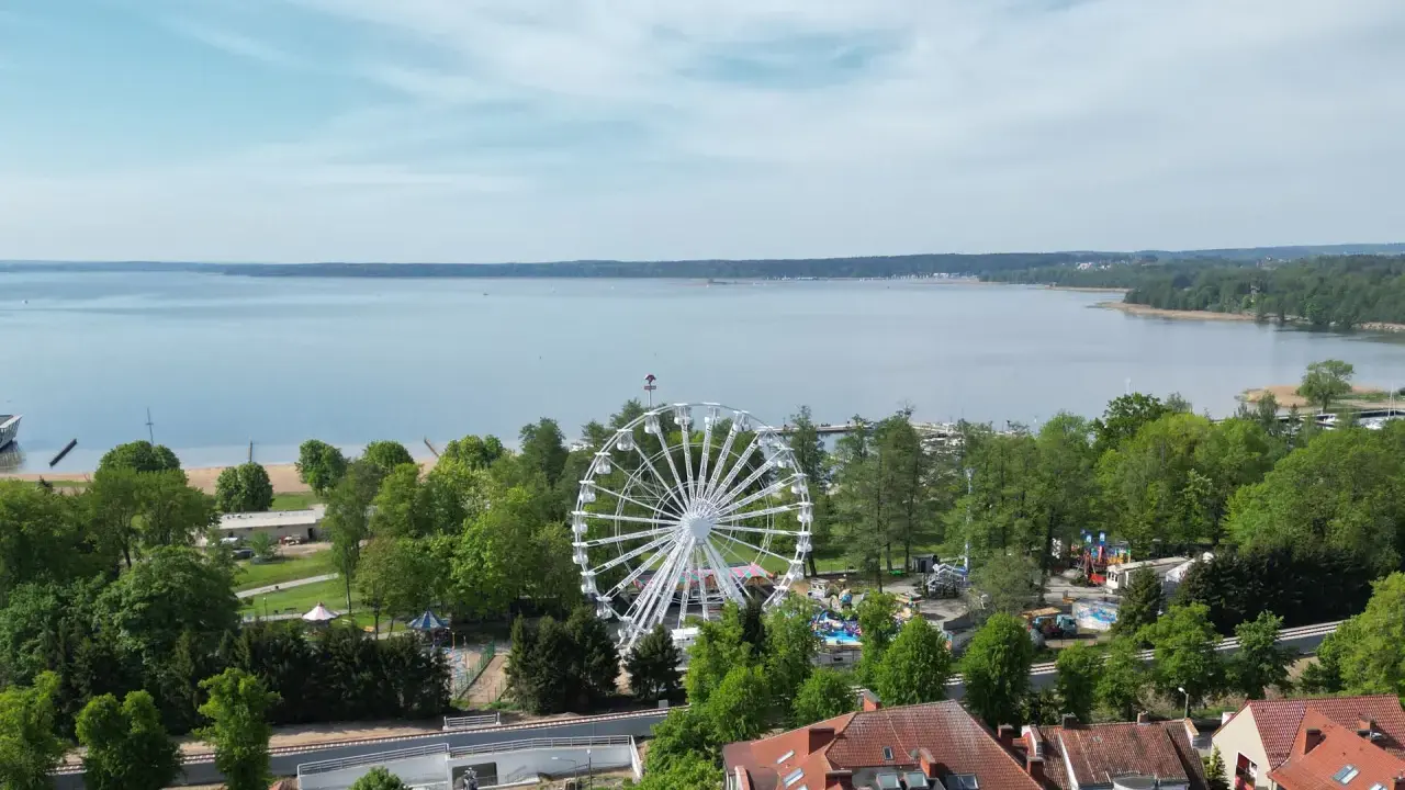 Widok na jezioro i park rozrywki z diabelskim młynem w Giżycku.