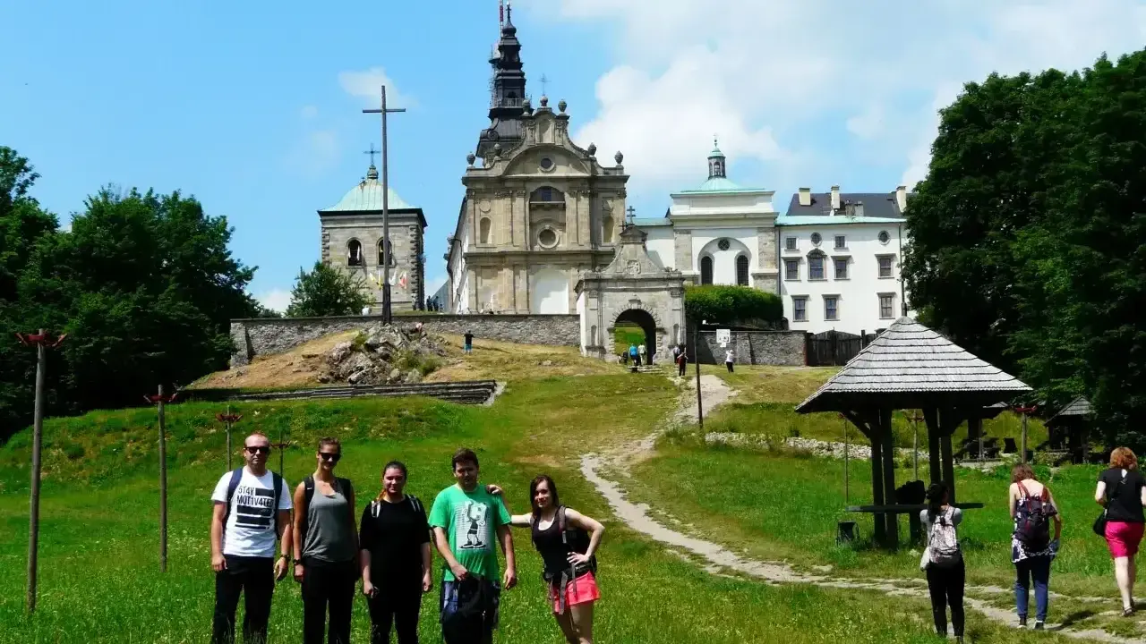 Grupa turystów na tle klasztoru na Świętym Krzyżu, miejscu pełnym łysa góra legend.