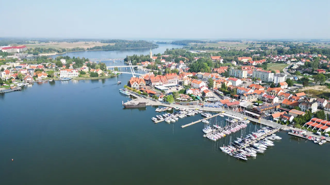 Malownicze miasteczko z mariną pełną żaglówek i domów z czerwonymi dachami. Idealne miejsce na letni wypoczynek, jakbyśmy byli na plaży w Mikołajkach.