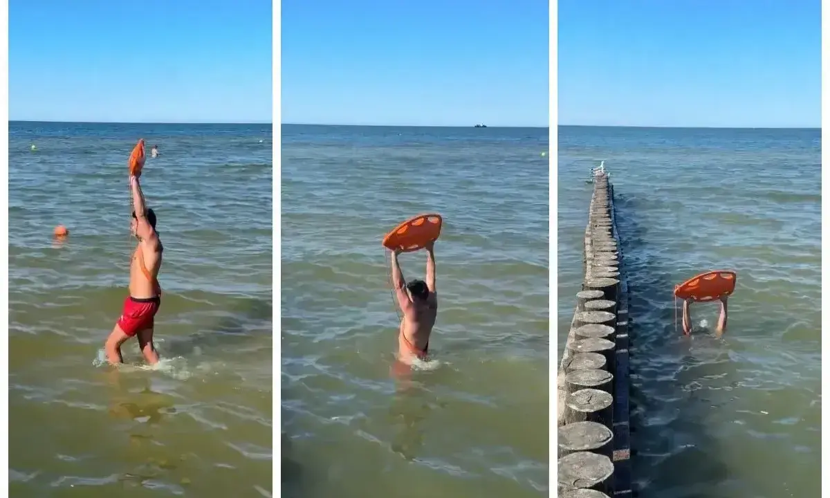 Ratownik z kołem ratunkowym przy falochronach nad morzem. Słońce, woda i bezpieczeństwo plażowiczów.