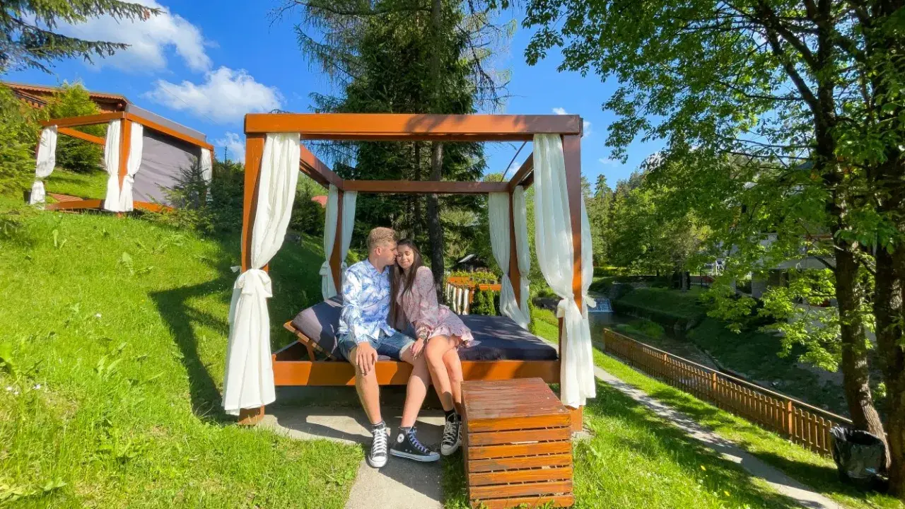 Para siedzi na łóżku pod baldachimem, idealne miejsce, gdzie na romantyczny weekend.