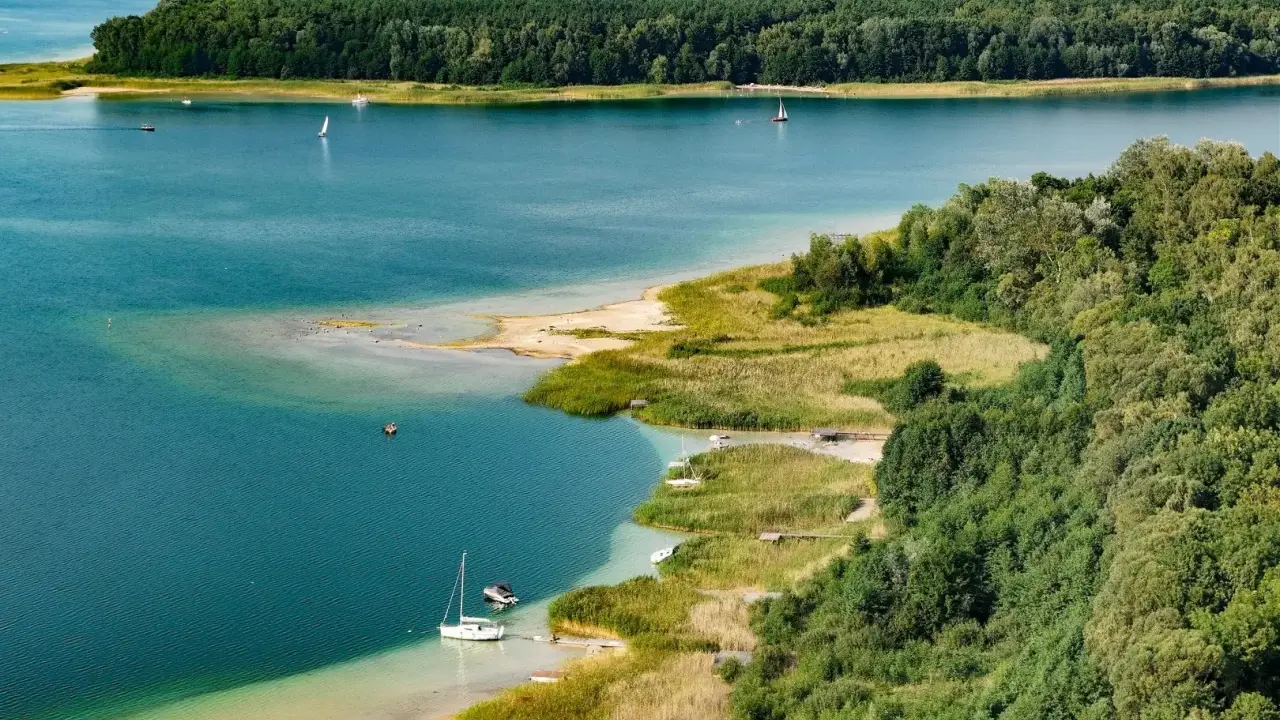 Turkusowa woda, piaszczyste plaże i zielone lasy tworzą malowniczy krajobraz. To **najczystsze jezioro w Polsce**, idealne do żeglowania i wypoczynku.