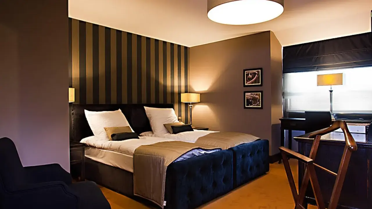Przytulny pokój hotelowy z dużym łóżkiem, idealny na romantyczny wypad. Co można robić w Lublinie z dziewczyną? Tu na pewno odpoczniecie.