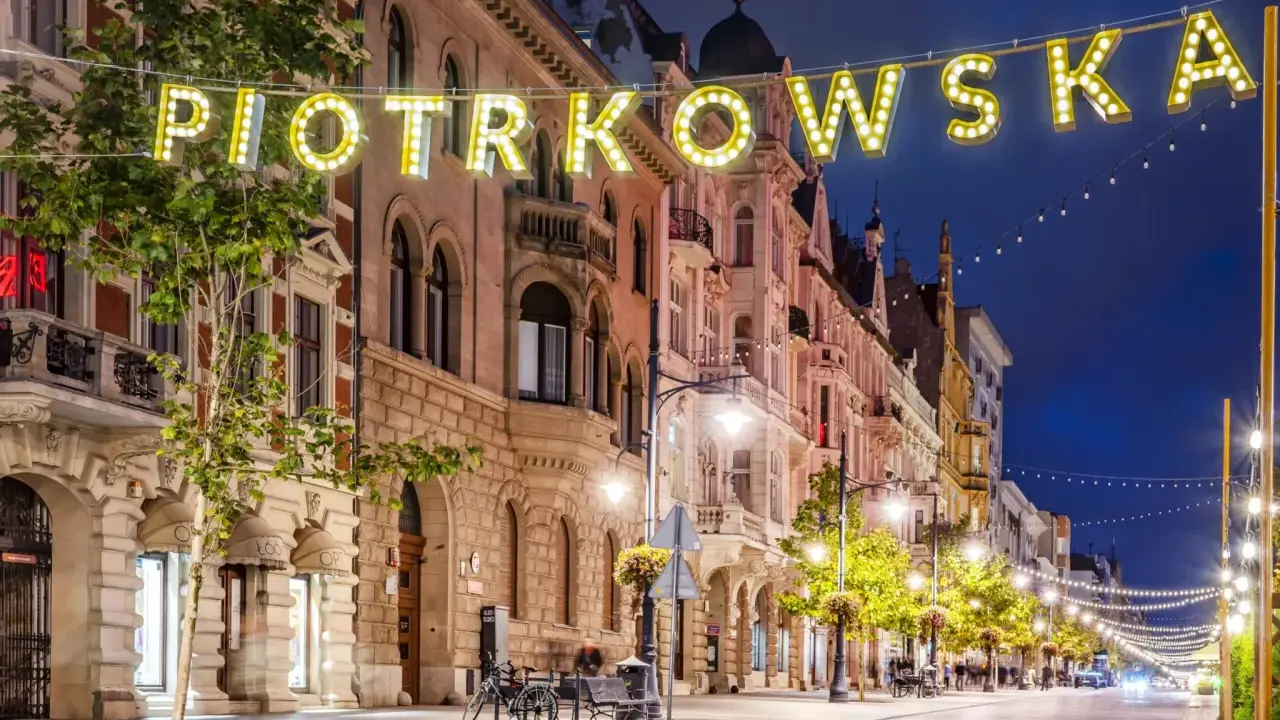 Ulica Piotrkowska nocą, rozświetlona neonami i girlandami, to jedna z głównych łódzkich atrakcji turystycznych.