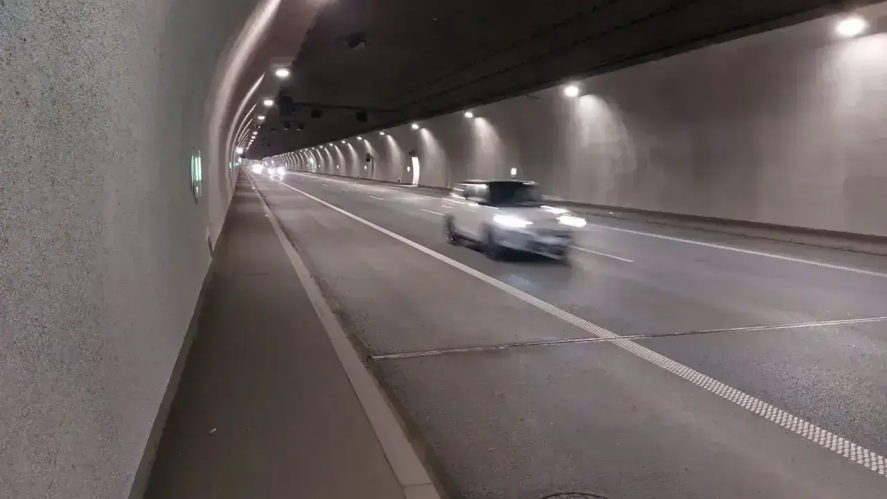 Biały samochód mknie przez oświetlony tunel w Zakopanem.