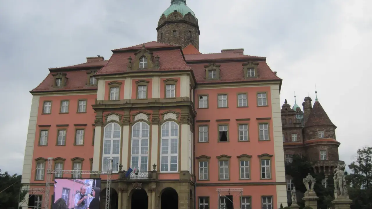 Zamek Książ z wieżą i ekranem LED przed fasadą, na którym wyświetlany jest obraz.