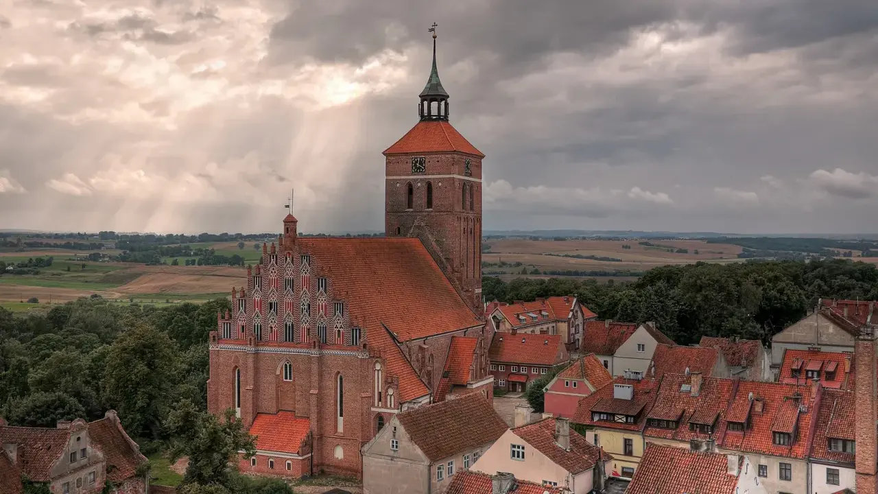 Gotycka ceglana architektura i malowniczy krajobraz Mazur, świadectwo bogatej historii regionu.