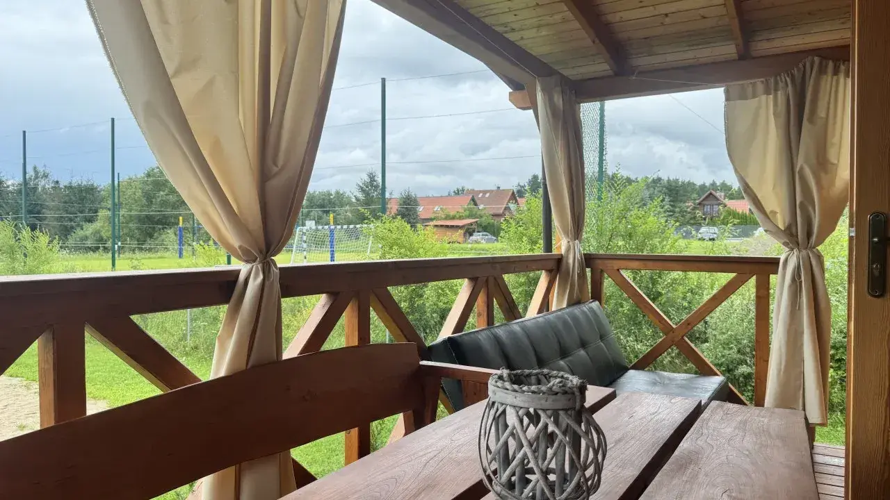 Idealne miejsce, gdzie na Mazury z dziećmi. Drewniany taras z widokiem na zieleń i boisko.