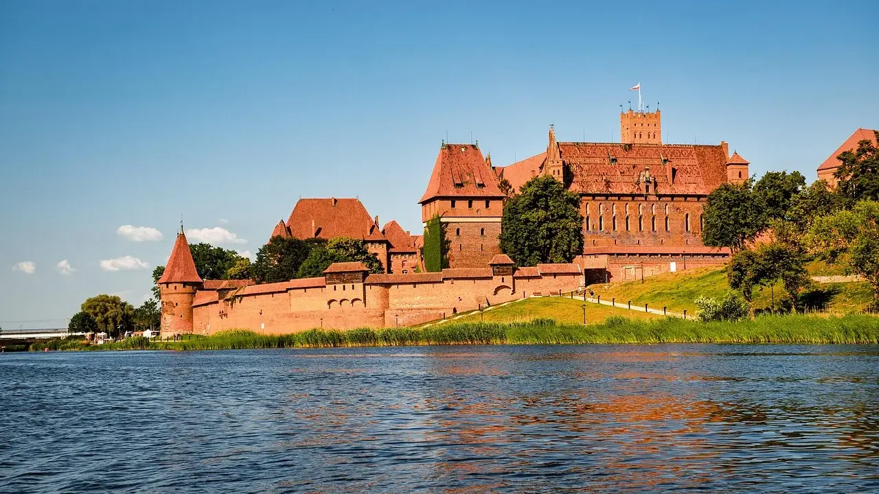 Zamek w Malborku, często uznawany za najlepsze muzeum w Polsce, majestatycznie wznosi się nad rzeką Nogat.
