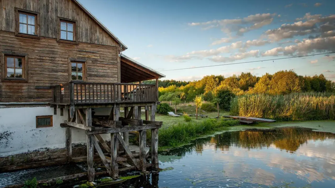 Drewniany młyn nad wodą, otoczony zielenią. Idealne miejsce na weekendowe wypady, szukając fajne miejsca niedaleko Warszawy na weekend.