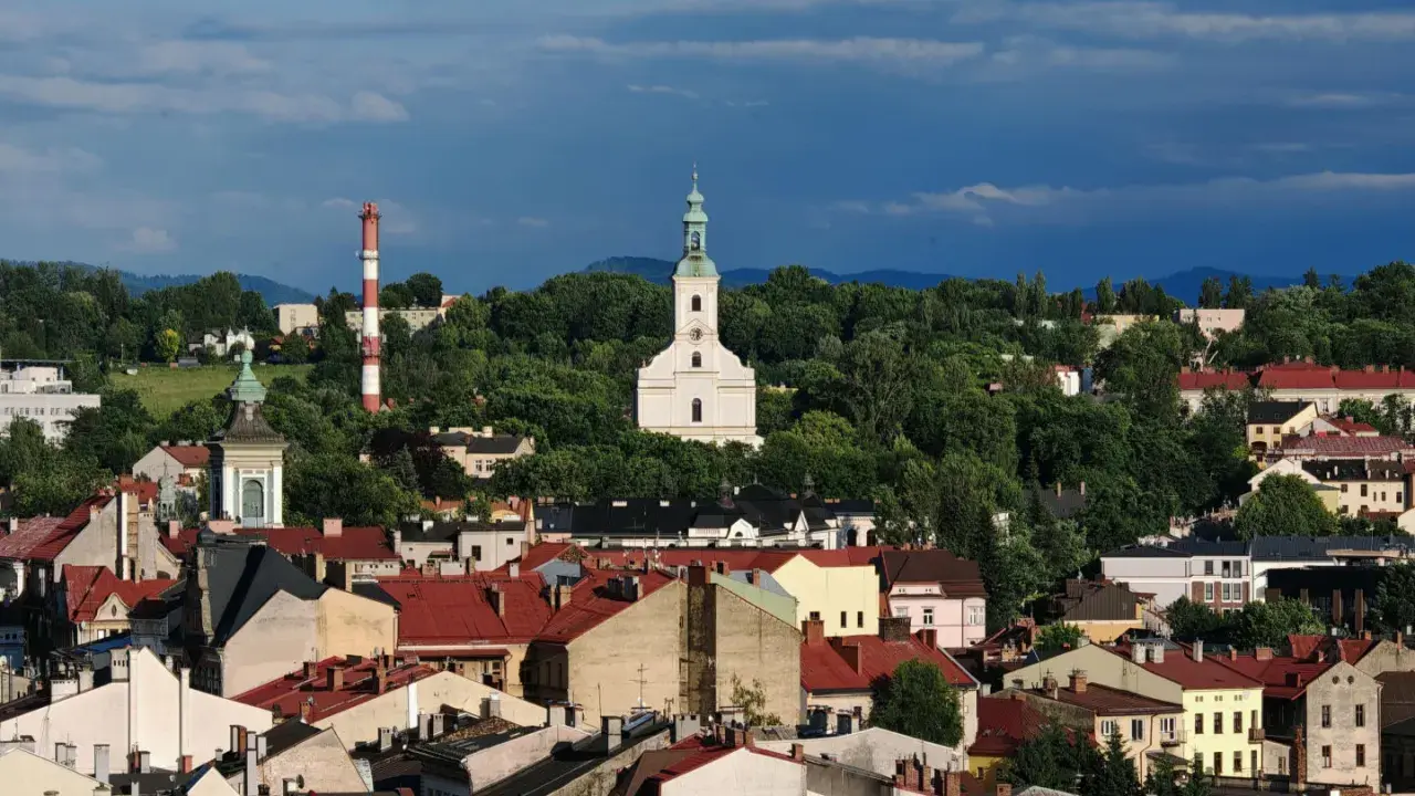 Widok na miasto z kościołem i wieżą, otoczone zielenią. To najstarsze miasto na Śląsku, pełne historii.