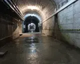 Wnętrze tunelu podczas zwiedzania elektrowni Solina. Mokra posadzka odbija światło lamp.