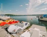 Kolorowe rowerki wodne i żaglówki czekają na gości nad jeziorem Drawsko.