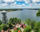Wieża widokowa nad pięknymi kaszubskimi jeziorami. Żaglówka sunie po wodzie, a wokół bujna zieleń.