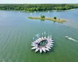 Żaglówki tworzą okrąg na jeziorze, idealne atrakcje Warmia i Mazury. W tle las i mała wyspa.