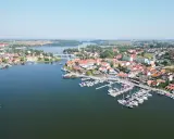 Malownicze miasteczko z mariną pełną żaglówek i domów z czerwonymi dachami. Idealne miejsce na letni wypoczynek, jakbyśmy byli na plaży w Mikołajkach.