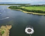 Kwiat z żaglówek na jeziorze, otoczony zielonymi polami i lasami. Piękny widok na Warmia i Mazury.