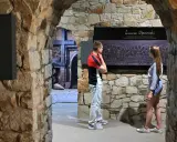 Zwiedzający podziwiają fragment nagrobka "Lament Opatowski" w kamiennych murach.