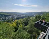 Widok z platformy widokowej na górze Markowca w Rumi. W dole rozciąga się miasto otoczone zielonymi wzgórzami.