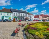 Kolorowy rynek z kwitnącymi rabatami i ławkami, idealne miejsce na wyjazd na weekend.