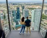 Para zwiedzająca Varso Tower taras widokowy, podziwia panoramę Warszawy.