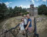 Rodzina pozuje do zdjęcia na tle kamiennego zamku, jednego z romantycznych miejsc na Podlasiu.