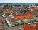 Widok z góry na kolorowy rynek z kamienicami, ratuszem i kościołem. To chyba najładniejszy rynek w Polsce, tętniący życiem.