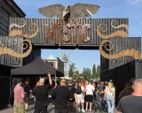 Tłum ludzi wchodzi przez bramę festiwalową "Mystic". To jedno z wielu wydarzeń kulturalnych, takich jak festiwale filmowe w Polsce.