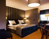 Przytulny pokój hotelowy z dużym łóżkiem, idealny na romantyczny wypad. Co można robić w Lublinie z dziewczyną? Tu na pewno odpoczniecie.