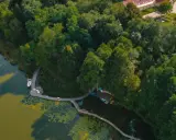 Idealne miejsce, gdzie nad jezioro w Polsce. Drewniana kładka prowadzi do łodzi i żaglówki, otoczone bujną zielenią.