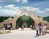 Kamienna brama "Magiczne Ogrody" zaprasza na świetne atrakcje dla nastolatków. Rodziny wchodzą do parku rozrywki.
