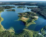 Malownicze jezioro Niesulice otoczone lasami, z wyspami i zabudowaniami na brzegu. Idealne miejsce na wypoczynek.