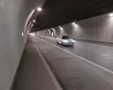 Biały samochód mknie przez oświetlony tunel w Zakopanem.