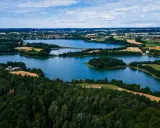 Krajobraz Kaszub z jeziorami, lasami i polami uprawnymi pod błękitnym niebem.
