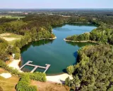 Malownicze jeziora w Zielonej Górze otoczone lasem, z drewnianym pomostem i piaszczystą plażą. Idealne miejsce na wypoczynek.