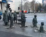 Słynne pomniki w Polsce: grupa postaci wychodząca z chodnika, symbolizująca przejście przez czas.