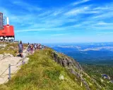 Grupa turystów wędruje ścieżką na Łabski Szczyt, podziwiając rozległą panoramę gór i dolin.