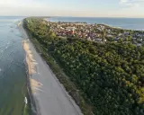 Piękna plaża i las, idealne miejsce, gdzie na majówkę. Widok z lotu ptaka na nadmorską miejscowość.
