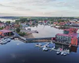 Mazury słyną z malowniczych jezior i portów pełnych jachtów. Widok na miasteczko z nowoczesnymi budynkami i wodnymi atrakcjami.