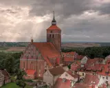 Gotycka ceglana architektura i malowniczy krajobraz Mazur, świadectwo bogatej historii regionu.