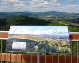 Widok z wieży widokowej Łysula na Beskid Sądecki i Tatry. Na tablicy informacyjnej rozpoznasz szczyty i pasma górskie.