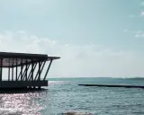 Nowoczesna architektura nad jeziorem Niegocin. Widok na wodę i niebo z chmurami. Atrakcje turystyczne Mazur.