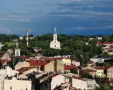 Widok na miasto z kościołem i wieżą, otoczone zielenią. To najstarsze miasto na Śląsku, pełne historii.