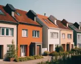 Szereg kolorowych domów z dachami pokrytymi dachówką. Ciekawe nazwy domów mogłyby pasować do tej uroczej uliczki.