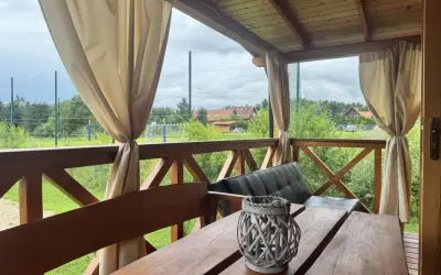 Idealne miejsce, gdzie na Mazury z dziećmi. Drewniany taras z widokiem na zieleń i boisko.