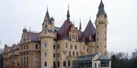 Imponujący zamek z kamienia z czerwonymi dachami i wieżami, jeden z wielu pięknych pałaców w Polsce.