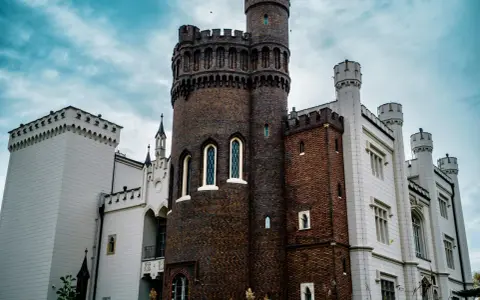 Zamek w Kórniku, jedna z najpiękniejszych atrakcji okolic Poznania, z ceglaną wieżą i białymi skrzydłami.