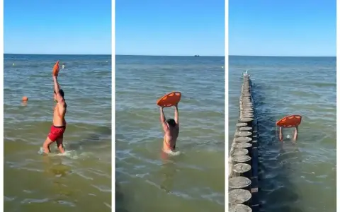 Ratownik z kołem ratunkowym przy falochronach nad morzem. Słońce, woda i bezpieczeństwo plażowiczów.