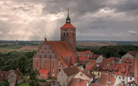 Gotycka ceglana architektura i malowniczy krajobraz Mazur, świadectwo bogatej historii regionu.